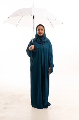 امرأة عربية بعباءة بترولية ومظلة بيضاء