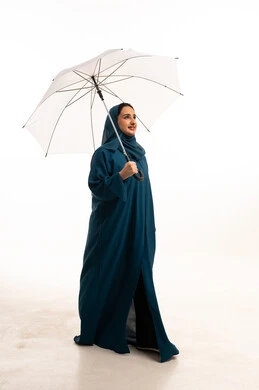 Saudi Woman in Teal Abaya Holding White Umbrella