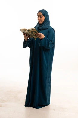 امرأة إماراتية تقرأ القرآن الكريم بعباءة تقليدية