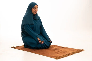 Saudi Woman Praying on Rug in Teal Abaya