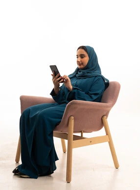 Emirati Woman in Abaya Using Smartphone in Studio