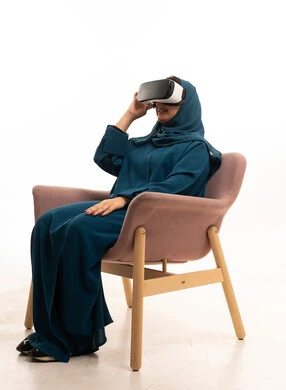 امرأة سعودية تستخدم نظارة الواقع الافتراضي بالعباءة