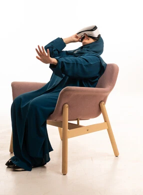 Saudi Woman Wearing Abaya Using VR Headset in Studio
