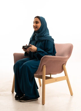 امرأة سعودية بالعباءة تلعب ألعاب الفيديو في الاستوديو