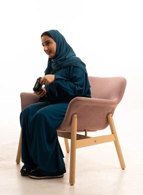 امرأة سعودية تحمل جهاز تحكم ألعاب في الاستوديو