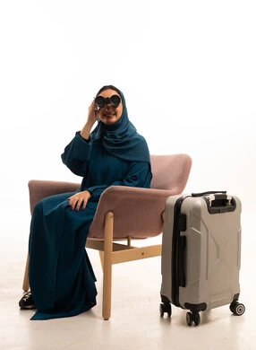 امرأة سعودية مع منظار وحقيبة سفر