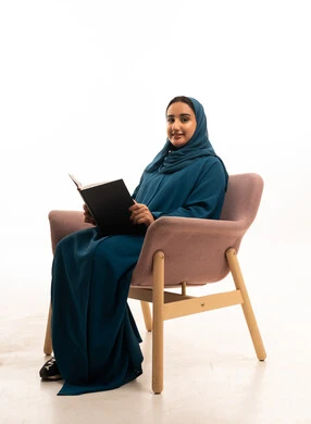 Saudi Woman Reading Book in Teal Abaya