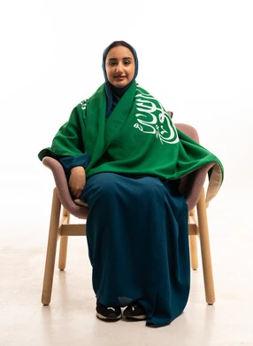 امرأة سعودية مع العلم الوطني في لقطة استوديو