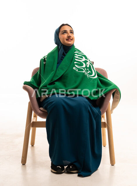 امرأة سعودية مع العلم الوطني بخلفية بيضاء