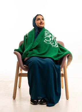 امرأة سعودية مع العلم الوطني بخلفية بيضاء