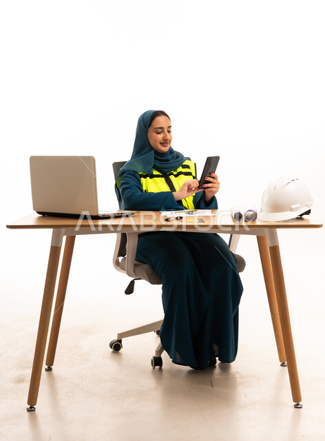 Emirati Female Engineer Using Smartphone at Office Desk