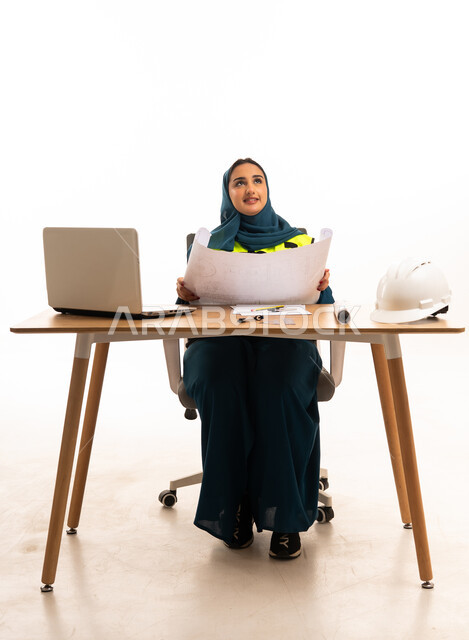 Saudi Female Engineer with Blueprints at Office Desk