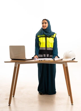 مهندسة مدنية سعودية مع مخططات هندسية وخوذة سلامة