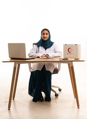 طبيبة سعودية مع حقيبة إسعافات أولية وجهاز كمبيوتر