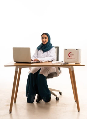 طبيبة سعودية تعمل على الكمبيوتر المحمول في المكتب