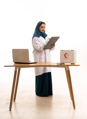 طبيبة سعودية تكتب على لوحة ملاحظات في استوديو