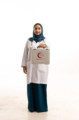 طبيبة سعودية تحمل حقيبة الإسعافات الأولية بخلفية بيضاء