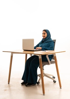 سيدة أعمال إماراتية تعمل على كمبيوتر محمول