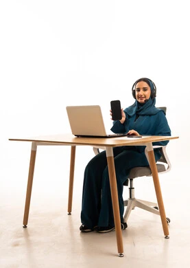 Arab Woman Working on Laptop Holding Smartphone