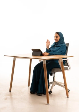 Saudi Woman Using Tablet for Video Call at Desk