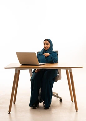 سيدة أعمال سعودية بعباءة تعمل على كمبيوتر محمول