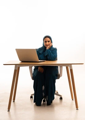 سيدة أعمال سعودية مع كمبيوتر محمول بخلفية بيضاء