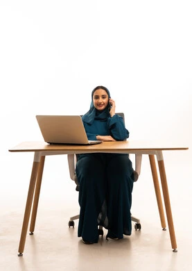 امرأة سعودية مع كمبيوتر محمول وهاتف بخلفية بيضاء