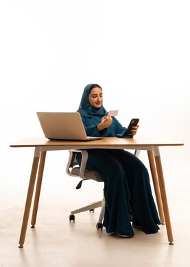 Saudi Woman Using Credit Card and Smartphone at Desk