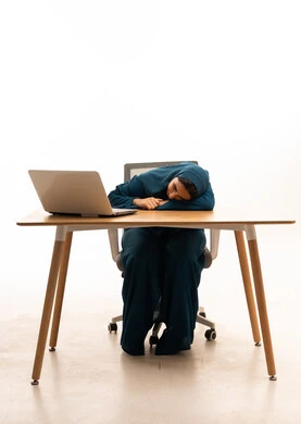 Exhausted Saudi Woman at Office Desk with Laptop
