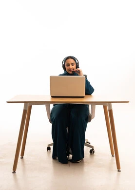 امرأة سعودية تعمل بجهاز محمول وسماعة رأس