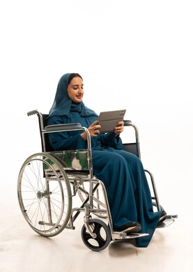 امرأة سعودية على كرسي متحرك تستخدم جهاز لوحي