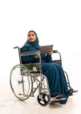 امرأة سعودية على كرسي متحرك مع جهاز لوحي