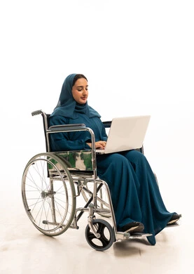 امرأة عربية على كرسي متحرك تستخدم كمبيوتر محمول