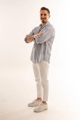 رجل سعودي يقف في استوديو مكتوف اليدين