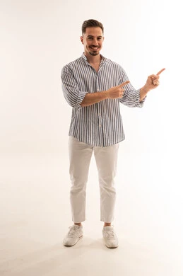 رجل سعودي مبتسم يشير أمام خلفية بيضاء