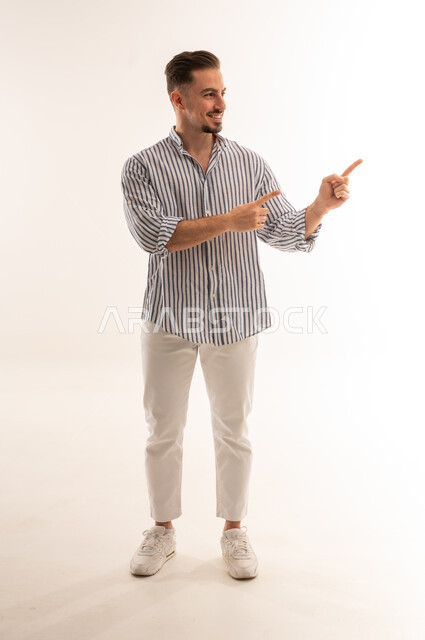 Smiling Saudi Man Pointing Aside on White Background