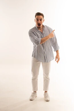 رجل سعودي مندهش يشير إلى الجانب بخلفية بيضاء