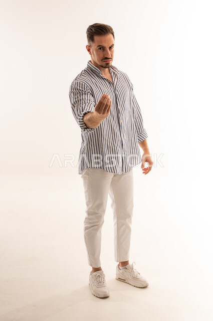 رجل سعودي يقوم بحركة تعبيرية باليد خلفية بيضاء