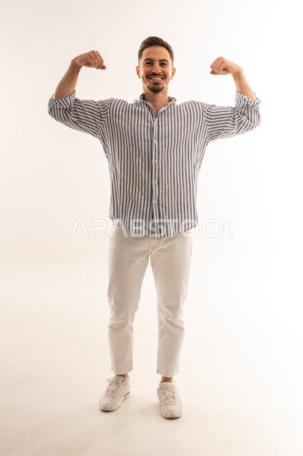 رجل سعودي يستعرض عضلاته في استوديو أبيض