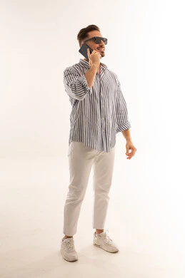 رجل سعودي يتحدث بالهاتف في استوديو بخلفية بيضاء