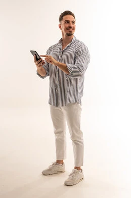 رجل سعودي يستخدم الهاتف الذكي في استوديو بخلفية بيضاء