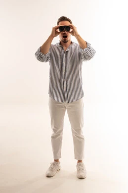 رجل سعودي ينظر عبر المنظار بتعبير مندهش في الاستوديو