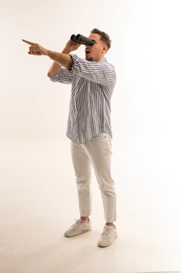 رجل سعودي يحمل منظار ويشير على خلفية بيضاء