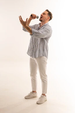 رجل سعودي يغني في الميكروفون بخلفية بيضاء