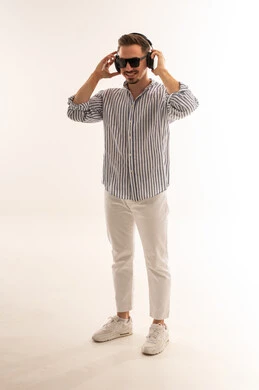 رجل سعودي يرتدي سماعات رأس في استوديو أبيض