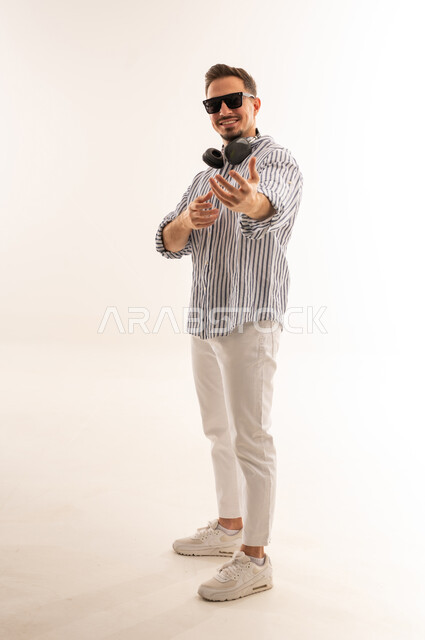 Saudi Man in White Studio with Headphones and Sunglasses