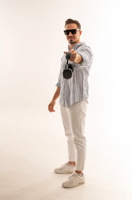 رجل سعودي يحمل سماعات رأس لاسلكية بخلفية بيضاء