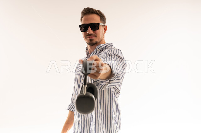 رجل سعودي يحمل سماعات رأس لاسلكية بخلفية بيضاء