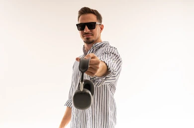 رجل سعودي يحمل سماعات رأس لاسلكية بخلفية بيضاء