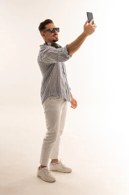 رجل سعودي يلتقط صورة سيلفي بالهاتف في الاستوديو